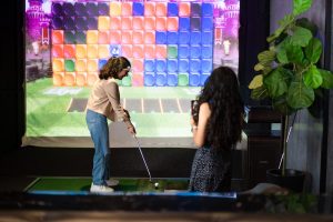 Niña disfrutando de una clase de golf en Mulligan's.