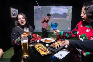 Grupo de empleados felices celebrando en Mulligan's, el lugar perfecto para posadas corporativas.