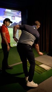 Jugador de golf perfeccionando su técnica en una clase personalizada en Mulligan’s Golf.